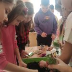 Dzieci sadzące zioła w donicy