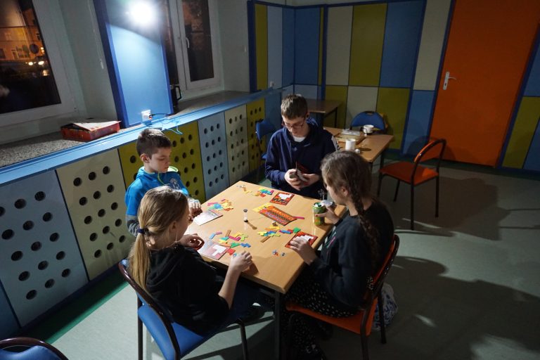 Zimowy wieczór gier planszowych, uczniowie grający przy stoliku